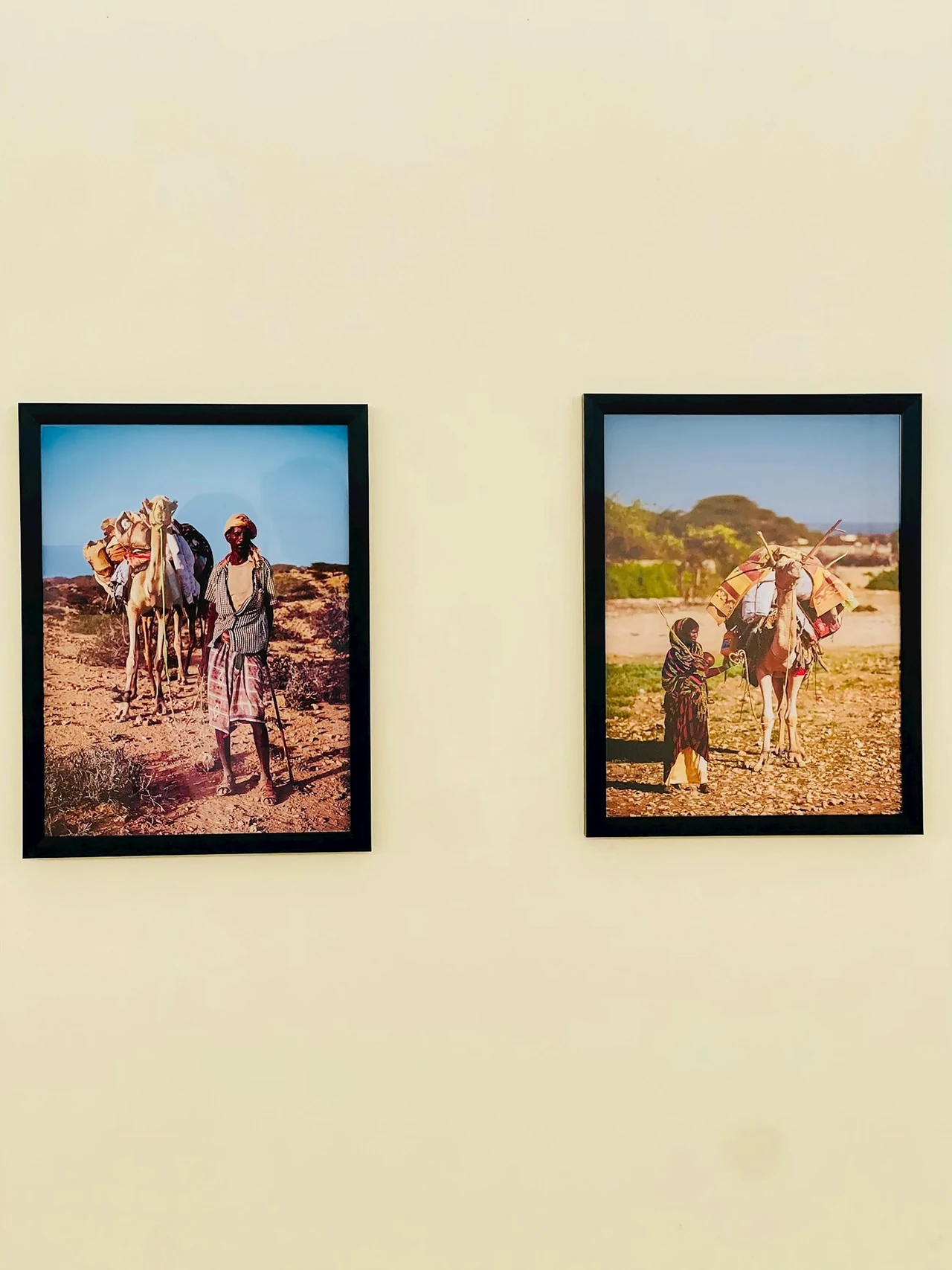 Two framed photographs hanging on a pale wall.