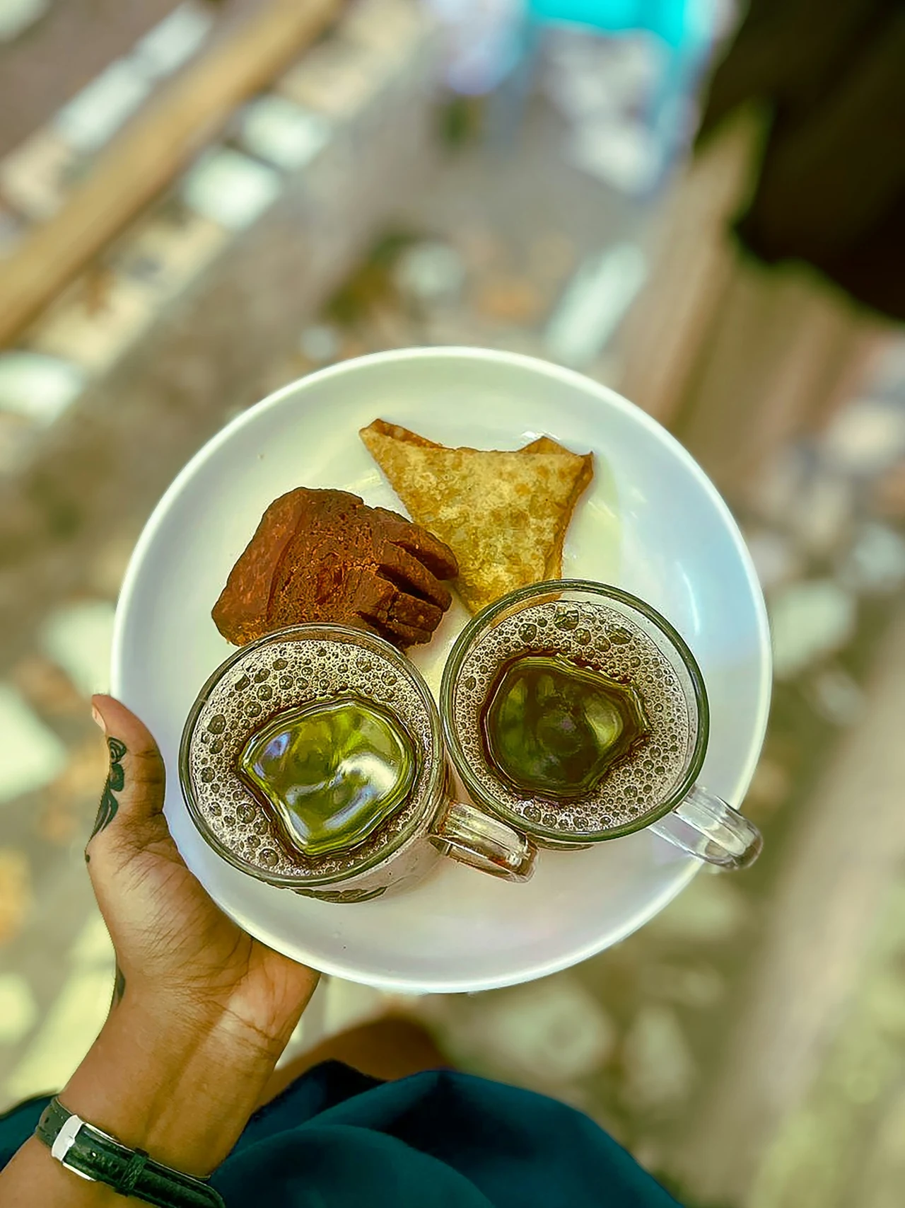 Two cups of Somali tea and snacks on a white plate.